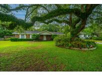 Charming brick home with a lush lawn and a large, mature tree providing shade at 930 Stiles Dr, Charleston, SC 29412