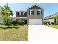 Charming two-story home featuring a spacious driveway and manicured lawn at 9711 Fanning Basket Ln, Ladson, SC 29456