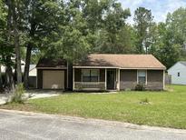 Charming single-story home with a well-manicured lawn and attached garage at 100 Lexington Pl, Goose Creek, SC 29445