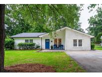 Charming single-story brick home featuring a bright blue front door and well-manicured lawn at 103 Four Iron Dr, Summerville, SC 29483