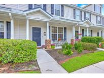 Charming townhome featuring well-manicured landscaping, a cozy front porch, and stylish architectural details at 108 Hemingway Cir, Summerville, SC 29483