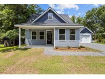 Charming bungalow with blue siding, a covered front porch, and a detached garage at 125 Ridge Rd, Summerville, SC 29485