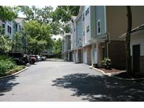 Street view of townhomes showing garages, sidewalks and parked cars on a sunny day at 1755 Central Park Rd # 9103, Charleston, SC 29412