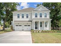 Charming two-story home boasts a welcoming front porch, manicured lawn, and an attached two-car garage at 2004 Sea Water Dr, Charleston, SC 29412