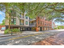 Brick building with a mix of residential and commercial spaces nestled in a charming neighborhood with mature trees at 21 George St # 203, Charleston, SC 29401