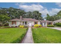 Charming single-story home featuring a well-manicured lawn, stone walkway, and inviting front entrance at 22 Charlestowne Rd, Charleston, SC 29407