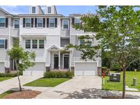 Charming townhome featuring an attached garage, manicured landscaping, and classic architectural details at 348 Spindlewood Way, Charleston, SC 29414