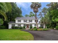 Charming two-story white home with black shutters and a circular driveway surrounded by lush landscaping at 375 Seewee Cir, Mount Pleasant, SC 29464