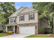 Two-story home with a stone accent front, white garage door, and neutral siding at 3873 Hanoverian Dr, Mount Pleasant, SC 29429