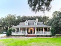 Charming home featuring a large, inviting front porch with white railings and a well-manicured lawn at 4150 Nature View Cir, Johns Island, SC 29455