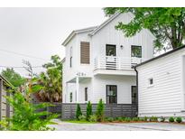 Two story home boasts white siding, a balcony, dark framed windows, and well-manicured landscaping at 42 Poinsett St # B, Charleston, SC 29403