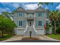 Charming two-story home with light grey siding, blue shutters, and a manicured front yard with palm tree at 5847 Back Bay Dr, Isle of Palms, SC 29451