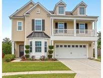 Charming two-story home with landscaped yard, covered porch, and three dormer windows at 9785 Black Willow Ln, Ladson, SC 29456