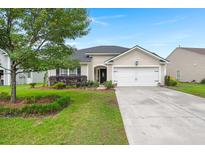 Charming single-story home featuring a well-manicured lawn, inviting curb appeal, and an attached two-car garage at 1103 Cates Ct, Summerville, SC 29483