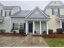 Charming townhome with gray siding, black shutters, white columns, and manicured landscaping at 112 Lake Jogassee Dr, Summerville, SC 29485