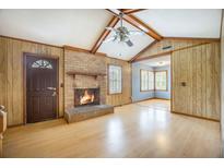 Spacious living room featuring a brick fireplace, wood paneling, and vaulted ceilings with exposed beams at 117 Myer Ln, Goose Creek, SC 29445