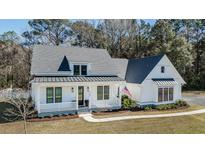 Charming two-story home boasts white siding, dark roof, and inviting front porch at 1174 Hitchfield Ln, Awendaw, SC 29429