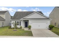 Charming single-story home with a well-manicured lawn and attached two-car garage at 121 Ancestry Ln, Moncks Corner, SC 29461