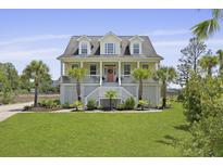 Charming two-story beach home with a lush green lawn, a picturesque porch, and beautiful palm trees at 1216 Rivers Reach Dr, Charleston, SC 29492