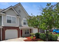 Charming townhome featuring brick accents, an attached garage, and well-manicured landscaping at 125 Greyson Cir, Goose Creek, SC 29445