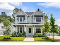 Charming two-story home with a manicured lawn and inviting front porch, complete with lush landscaping at 125 Integrity Ln, Charleston, SC 29492
