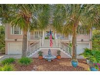 Charming home with palm trees, an American flag, elegant fountain and double staircase leading to the front door at 1308 Divot Ct, Mount Pleasant, SC 29466