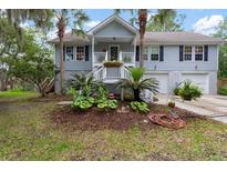 Charming two-story home with a well-manicured lawn, landscaped garden, and welcoming front porch at 1604 Macoma Dr, Mount Pleasant, SC 29466
