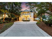 Beautiful two-story home with a spacious driveway and a double front porch surrounded by lush landscaping at 1635 Bull Creek Ln, Charleston, SC 29414