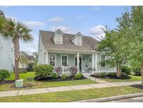 Charming two-story home with a quaint front porch and lush, landscaped yard at 1822 Grovehurst Dr, Charleston, SC 29414
