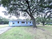 Charming single-story home with a well-maintained yard, mature trees, and a welcoming front porch at 1871 Grimball Rd, Charleston, SC 29412