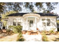 Charming white home with unique arched porch, brick accents, and beautiful landscaping at 203 Weiters St, Walterboro, SC 29488
