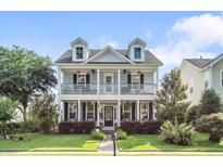Charming two-story home featuring double porches, dormer windows, and a well-manicured front lawn at 216 Foxbank Plantation Blvd, Moncks Corner, SC 29461