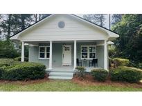 Charming home featuring a covered porch, round window, and freshly landscaped front yard at 217 Quaker Rd, Saint George, SC 29477