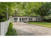Charming single-story home featuring a well-manicured lawn, mature trees, and a cozy front porch at 344 Lantana Dr, Charleston, SC 29407