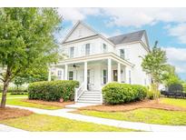 Charming two-story home with a inviting front porch, well-manicured lawn, and lush landscaping at 3707 Gambrill Ln, Mount Pleasant, SC 29466