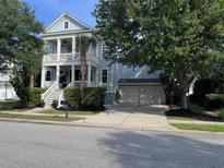 Charming light blue two-story home with a double garage, a balcony, and a well-manicured lawn at 4073 Blackmoor St, Mount Pleasant, SC 29466