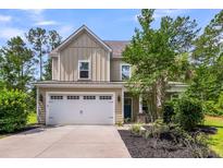Inviting two-story home boasts a well-manicured lawn, two-car garage and a covered porch at 5725 Caviar Ct, Johns Island, SC 29455