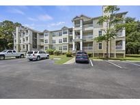 A view of the building exterior with parking spaces and manicured landscaping at 700 Daniel Ellis Dr # 10305, Charleston, SC 29412