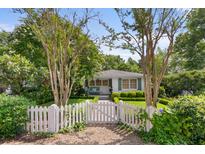 Charming home featuring a picket fence, manicured lawn, and lush landscaping, offering great curb appeal at 708 Pitt St, Mount Pleasant, SC 29464