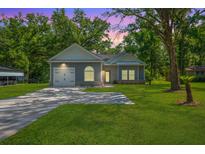 Charming single-story home with a lush green lawn and a long driveway leading to an attached garage at 8453 Charleston Hwy, Walterboro, SC 29488