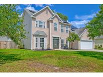 Charming two-story home with lush green lawn and traditional architectural details at 9682 Pebble Creek Blvd, Summerville, SC 29485