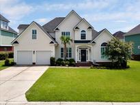 Beautifully landscaped two-story home featuring a two-car garage and manicured lawn at 1003 Jervey Point Rd, Wando, SC 29492