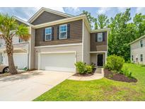 A well-maintained townhouse showcasing a two-car garage, manicured lawn, and appealing exterior finishes at 124 Bright Meadow Rd, Summerville, SC 29483