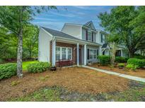 Charming townhouse with brick accents, complemented by lush green landscaping and a welcoming bench at 1304 Elm Hall Cir, Summerville, SC 29483