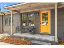 Inviting home exterior with a bright yellow door and charming front porch seating at 1320 Bresee St, Charleston, SC 29412