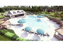A luxurious community pool featuring lounge chairs, umbrellas, covered seating areas, and a spacious deck for relaxation at 140 Lilac Grove Way, Summerville, SC 29486