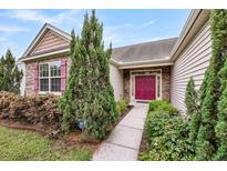 Charming home featuring a red front door, stone accents, manicured landscaping, and lovely red shutters at 193 Cypress Forest Dr, Moncks Corner, SC 29461
