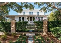 Charming two-story home featuring lush landscaping, a brick walkway, and an American flag at 222 Haddrell St, Mount Pleasant, SC 29464