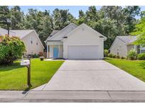 Charming single-Gathering home featuring a bright blue door, two-car garage, and well-maintained lawn at 252 Island Green Rd, Goose Creek, SC 29445