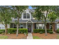 Charming townhouse featuring a well-kept lawn, lush bushes, and welcoming entrance at 402 Pine Bluff Dr, Summerville, SC 29483